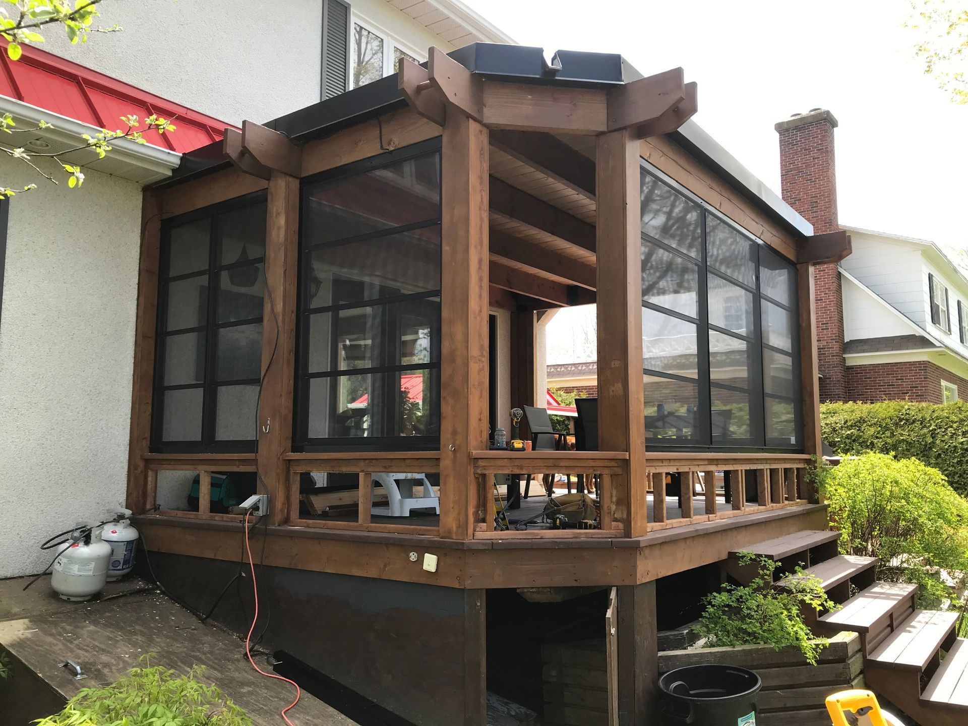Un porche grillagé est en cours de construction sur le côté d'une maison.