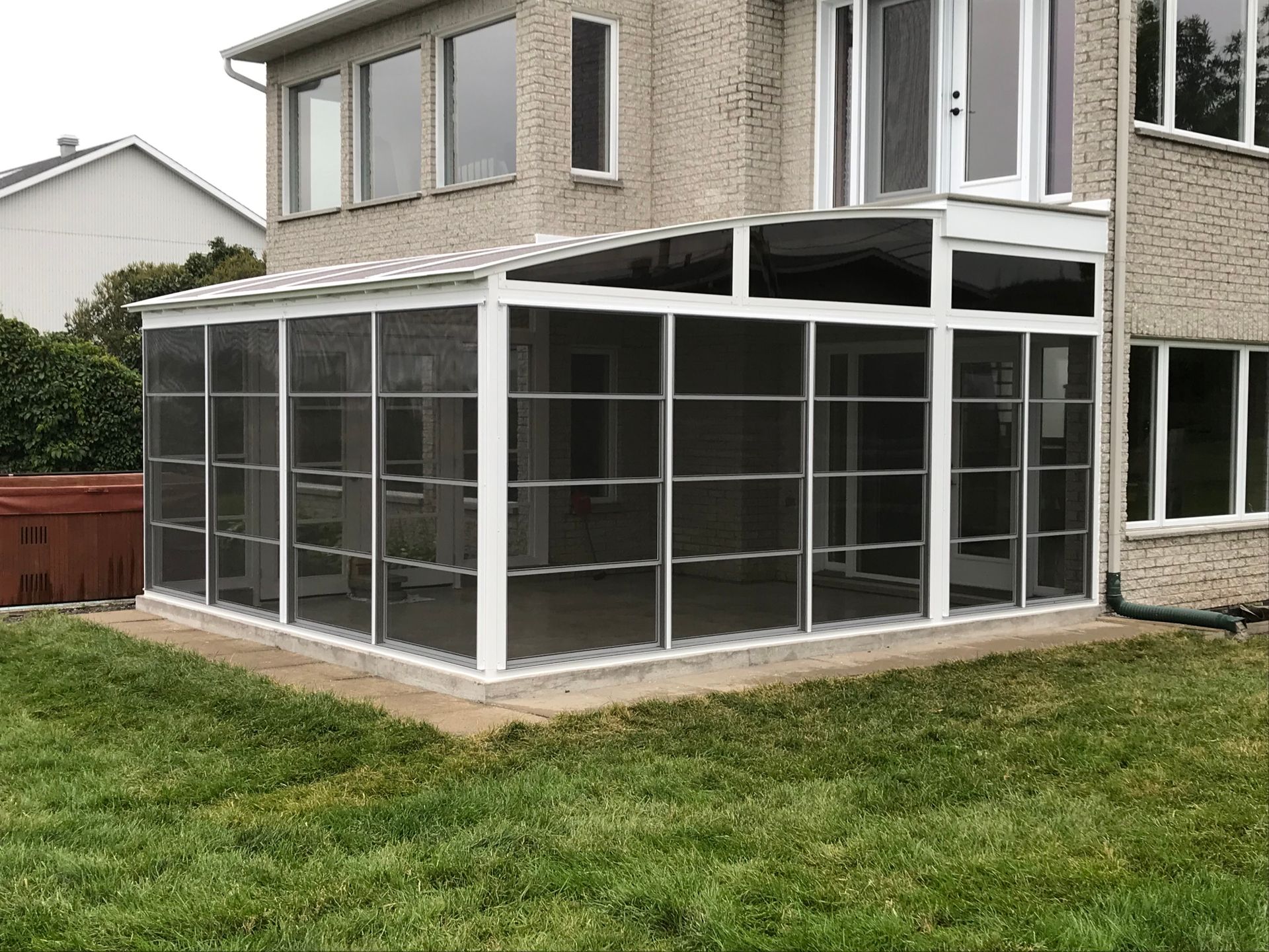 Il y a un porche grillagé dans l'arrière-cour d'une maison.