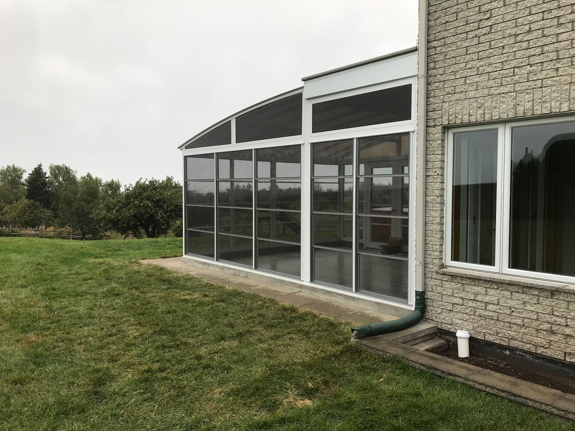 Il y a un porche grillagé sur le côté d'une maison.