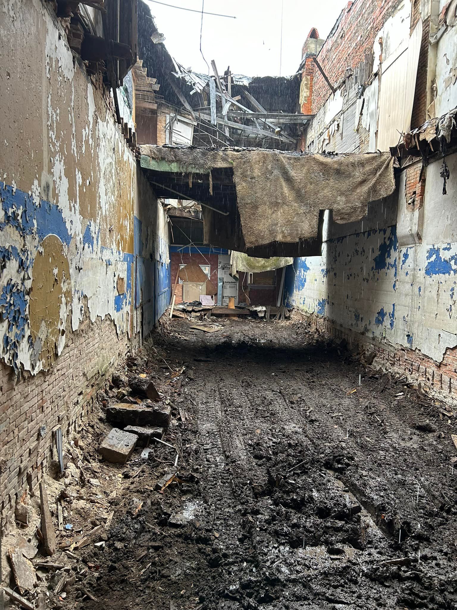 Woman in straw hat smiles, holding wine glass near a lake.