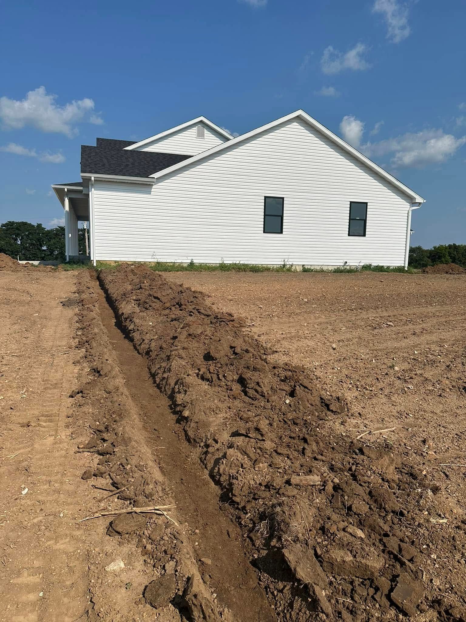 Woman in straw hat smiles, holding wine glass near a lake.