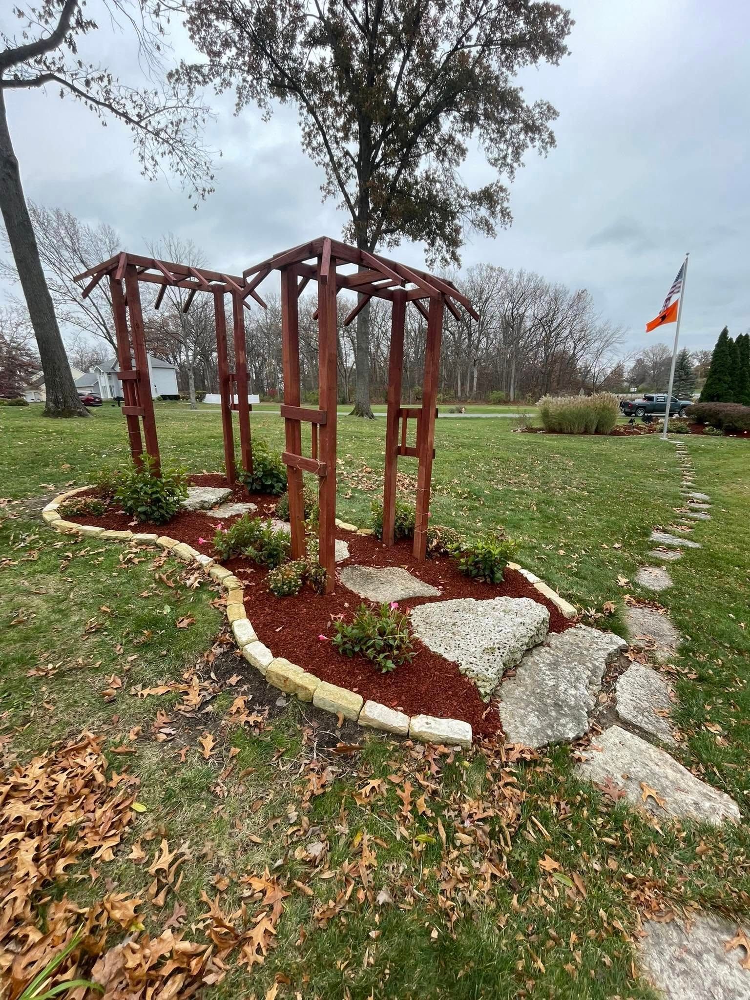 Woman in straw hat smiles, holding wine glass near a lake.
