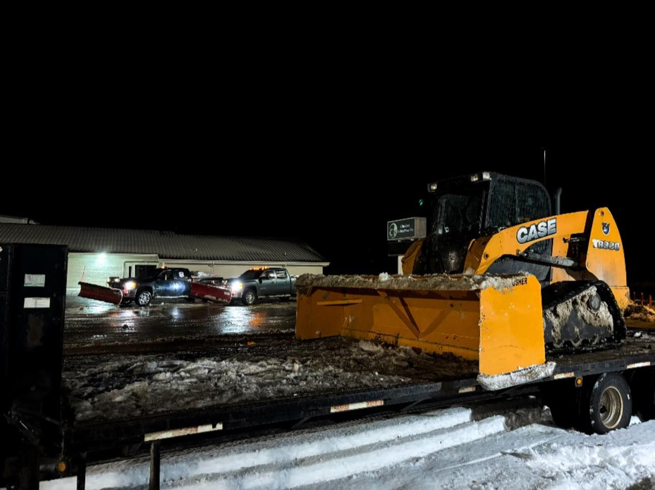 Woman in straw hat smiles, holding wine glass near a lake.