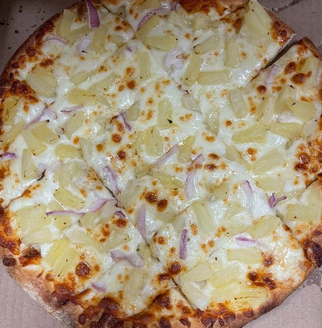 A pizza , bread sticks , chicken sticks , and a bowl of dipping sauce on a table.