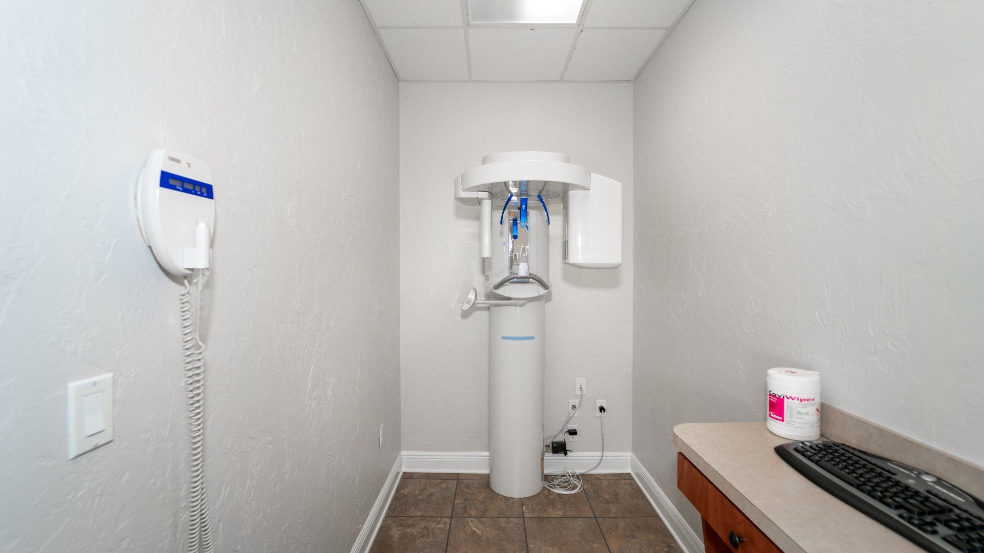 A dental office with a computer and a x-ray machine.