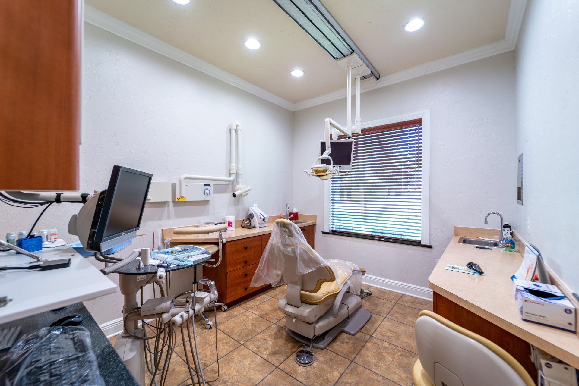 A dental office with a dental chair and a window.