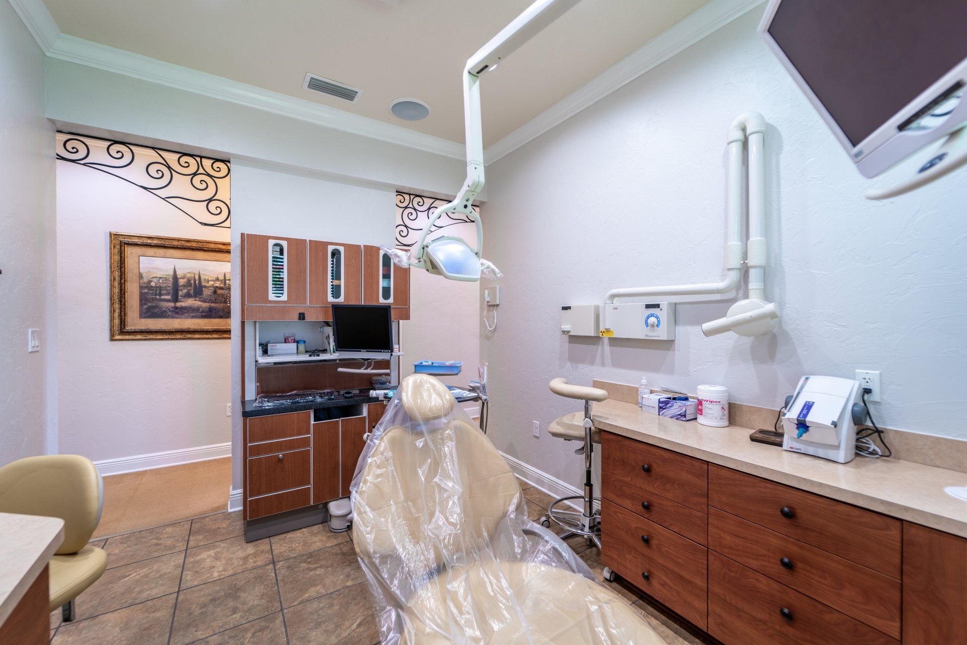 A dental office with a dental chair and a television on the wall.