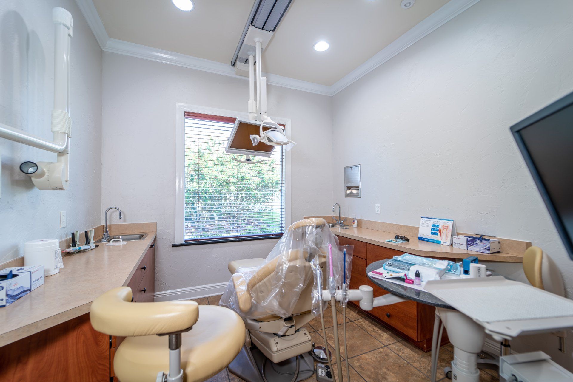 A dental office with a dental chair and a window.