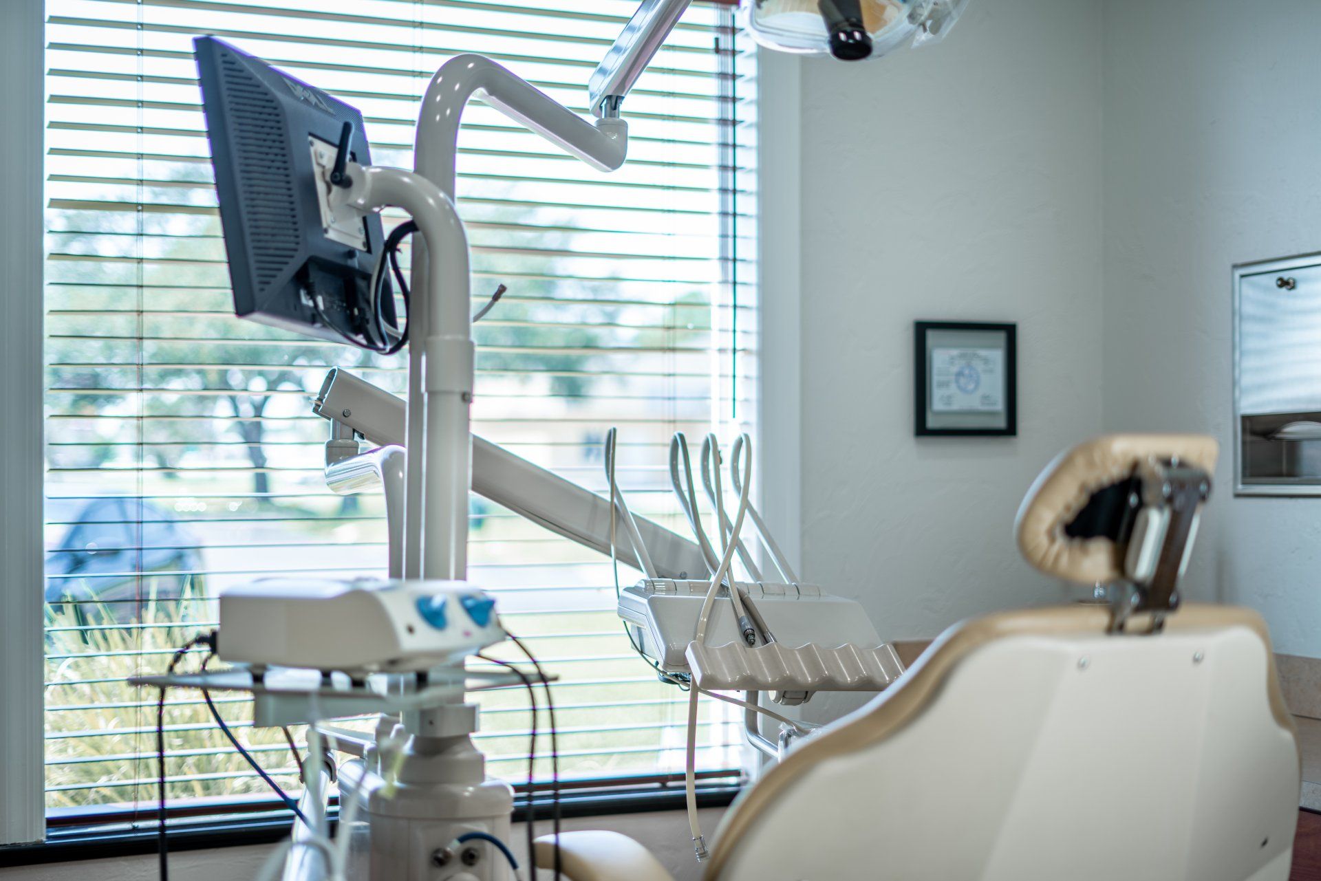 A dental office with a dental chair and a monitor.