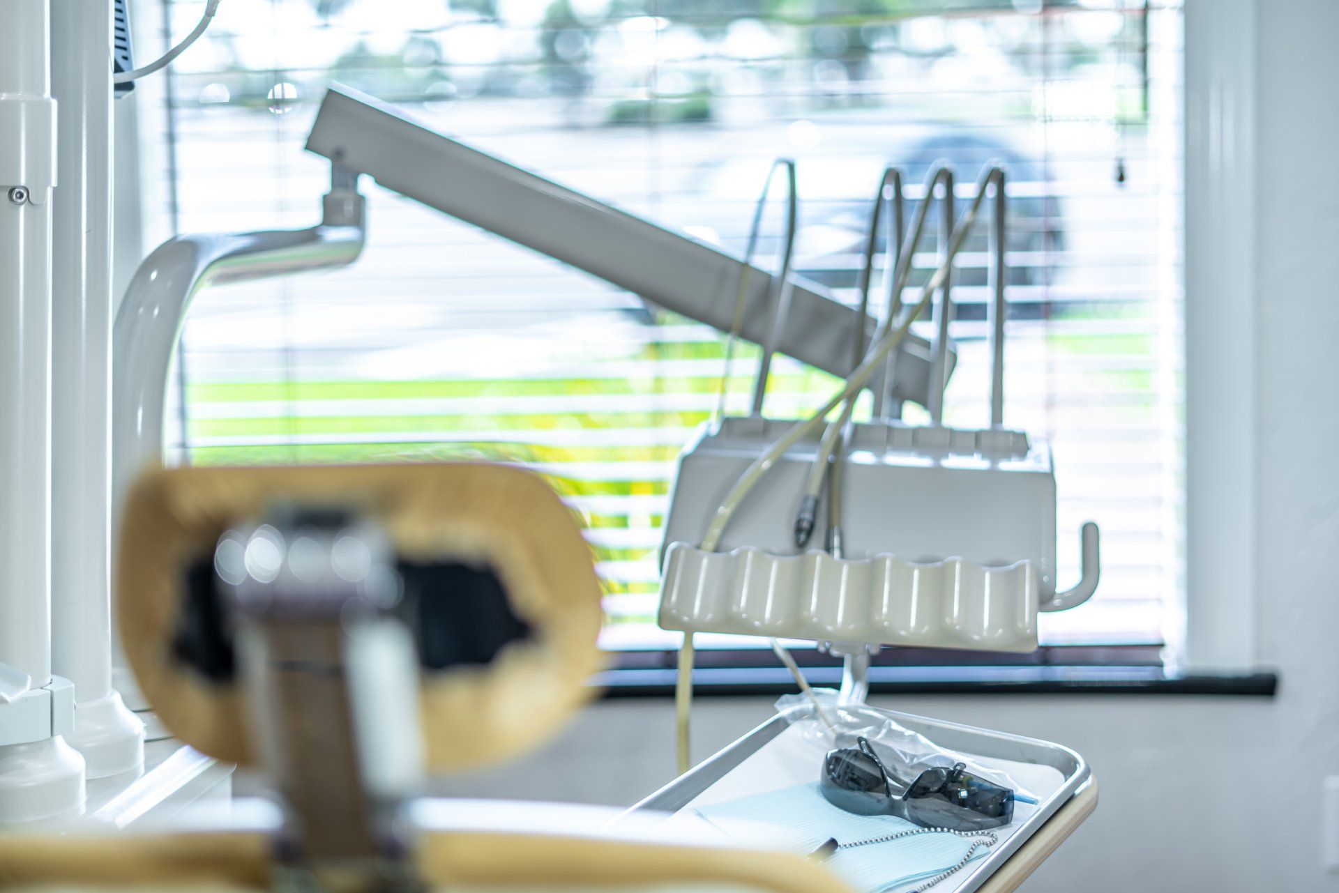 A dental chair is sitting in front of a window in a dental office.