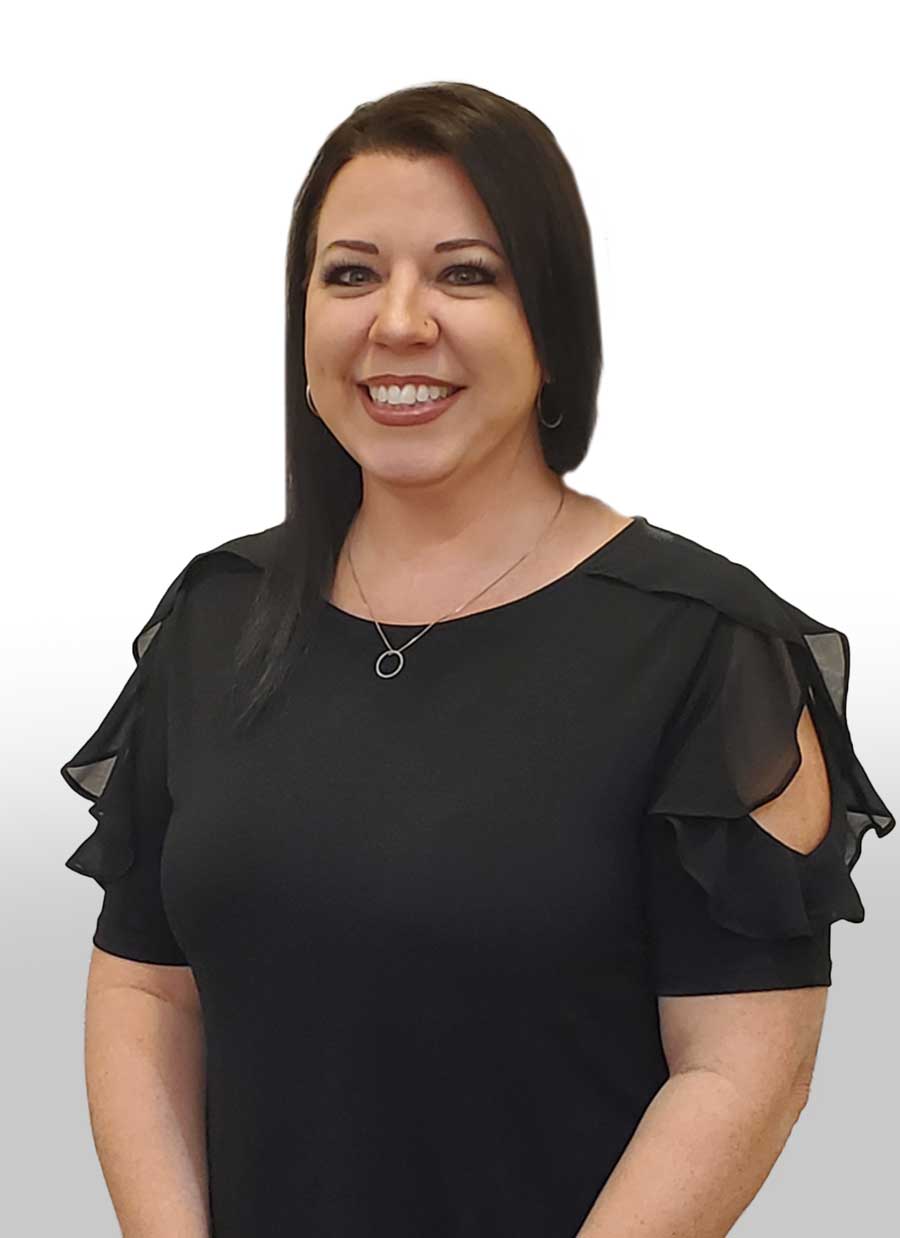 A woman in a black dress is smiling and wearing a necklace.