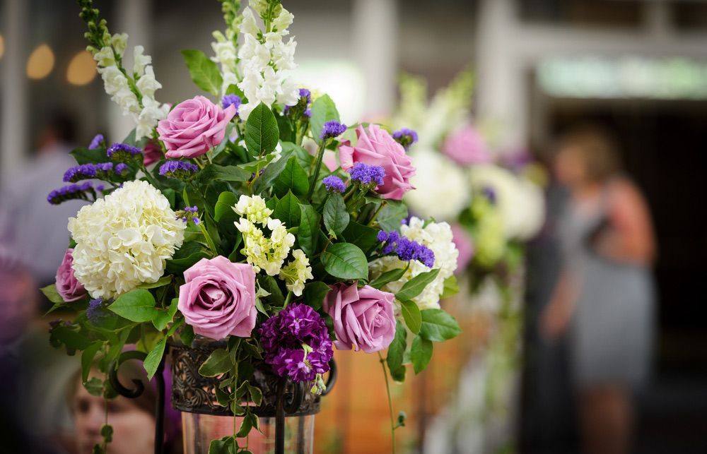 A Vase Filled with Purple and White Flowers Is Sitting on A Table — Pick-A-Bunch Florists & Gifts In Armstrong Beach, QLD