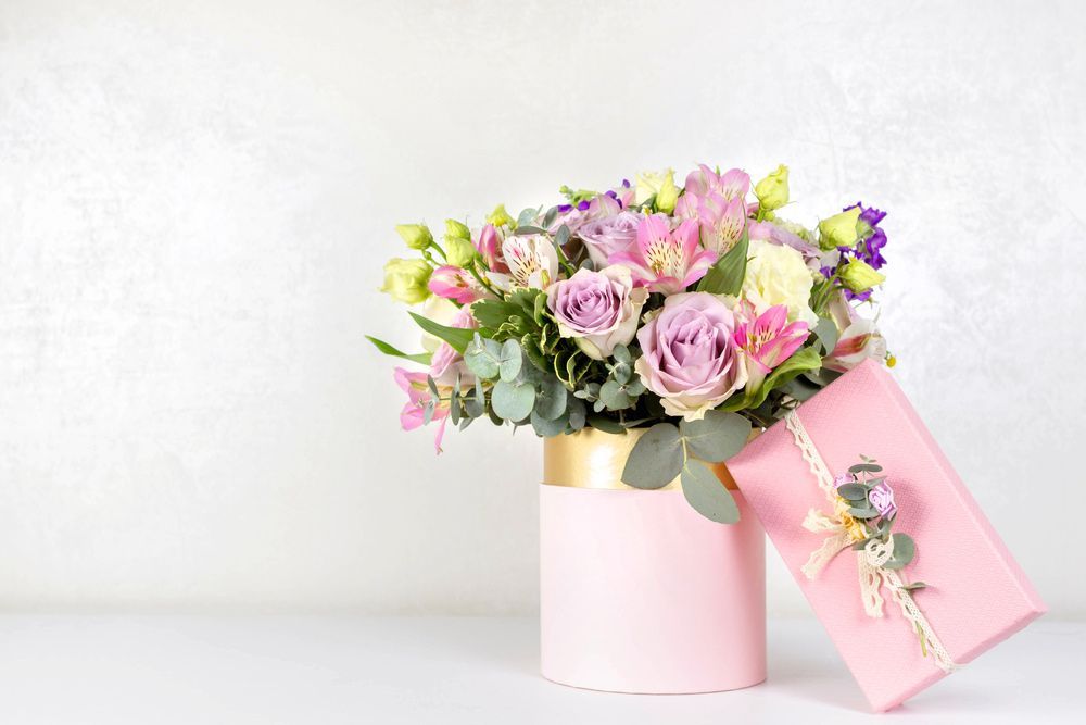 A Bouquet of Flowers in A Pink Vase Next to A Pink Gift Box — Pick-A-Bunch Florists & Gifts In Koumala, QLD