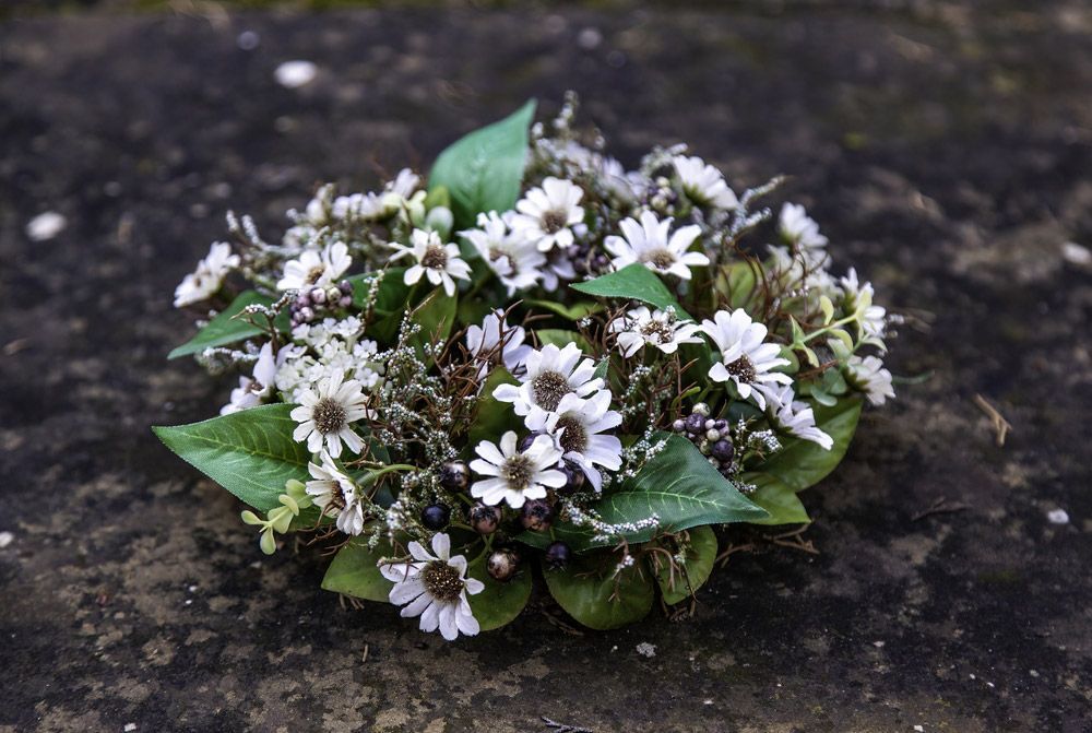 A Bouquet of White Flowers and Green Leaves Is Sitting on The Ground — Pick-A-Bunch Florists & Gifts In Hay Point, QLD
