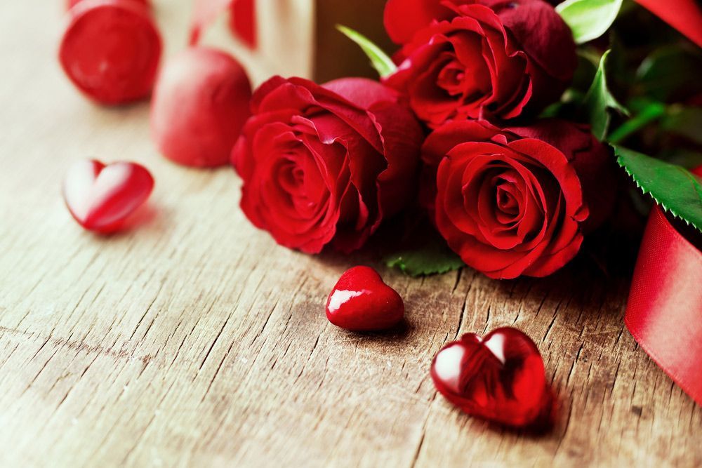 A Bouquet of Red Roses and Red Hearts on A Wooden Table — Pick-A-Bunch Florists & Gifts In Sarina, QLD