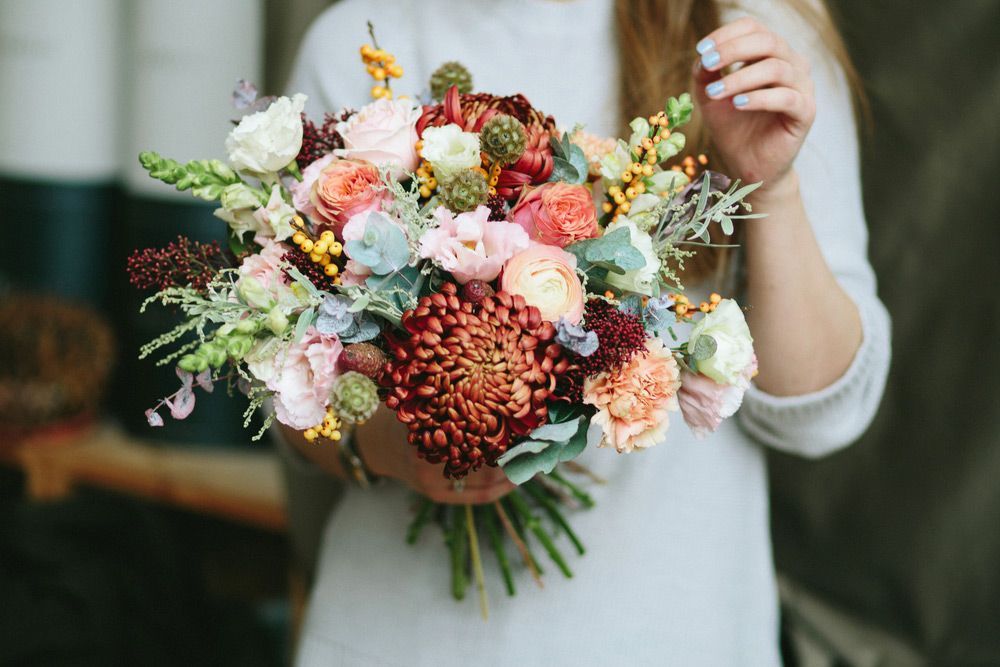 A Woman Is Holding a Bouquet of Flowers in Her Hands — Pick-A-Bunch Florists & Gifts In Armstrong Beach, QLD