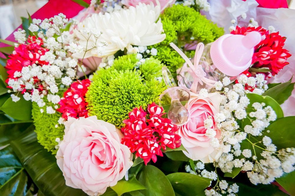 A Close up Of a Bouquet of Flowers with A Pink Bottle in The Middle — Pick-A-Bunch Florists & Gifts In Alligator Creek, QLD