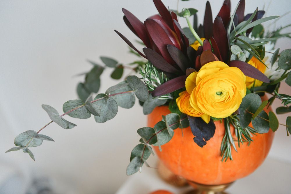 A Pumpkin Filled with Flowers and Leaves on A Table — Pick-A-Bunch Florists & Gifts In Hay Point, QLD