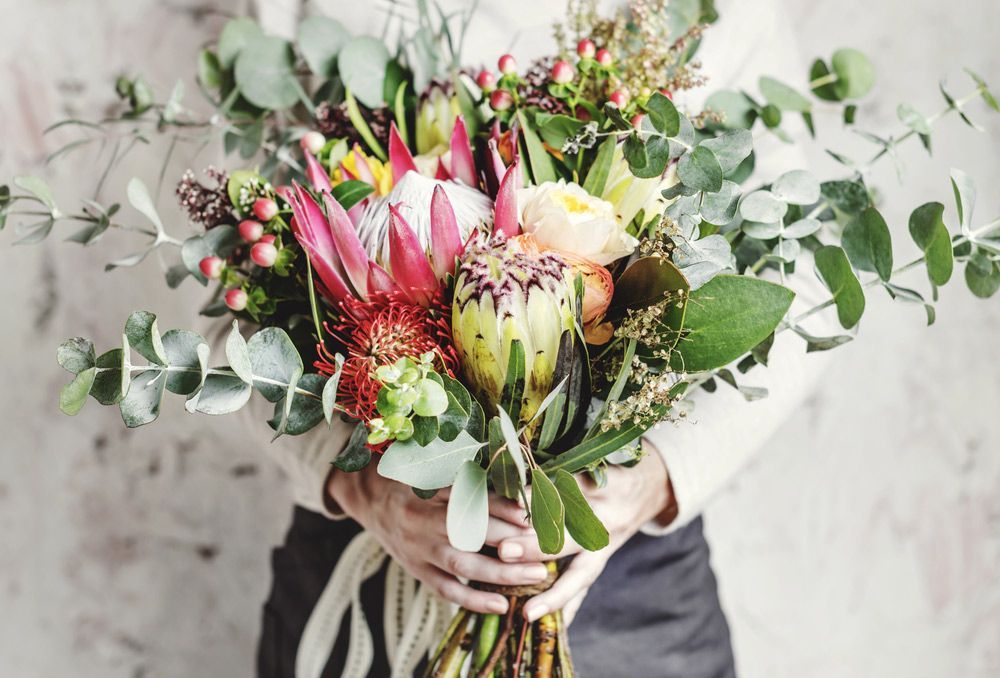 A Woman Is Holding a Bouquet of Flowers in Her Hands — Pick-A-Bunch Florists & Gifts In Alligator Creek, QLD