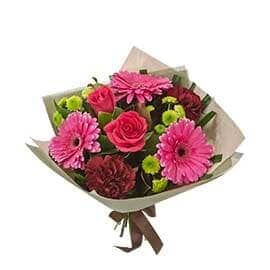 A Bouquet of Pink Flowers Wrapped in White Paper with A Brown Ribbon — Pick-A-Bunch Florists & Gifts In Sarina, QLD