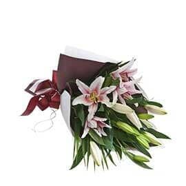 A Bouquet of Pink and White Lilies Wrapped in Brown Paper with A Red Ribbon — Pick-A-Bunch Florists & Gifts In Sarina, QLD