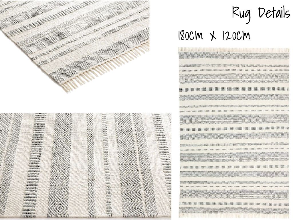 A rug with a black and white striped pattern and fringe