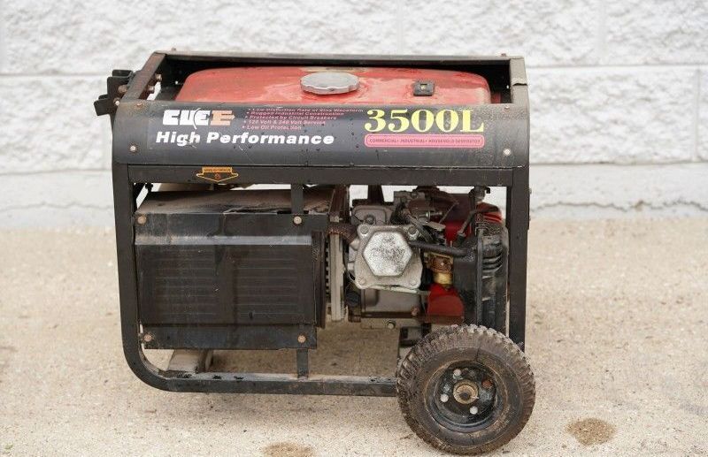 A green and white aerial lift is parked in front of a building.