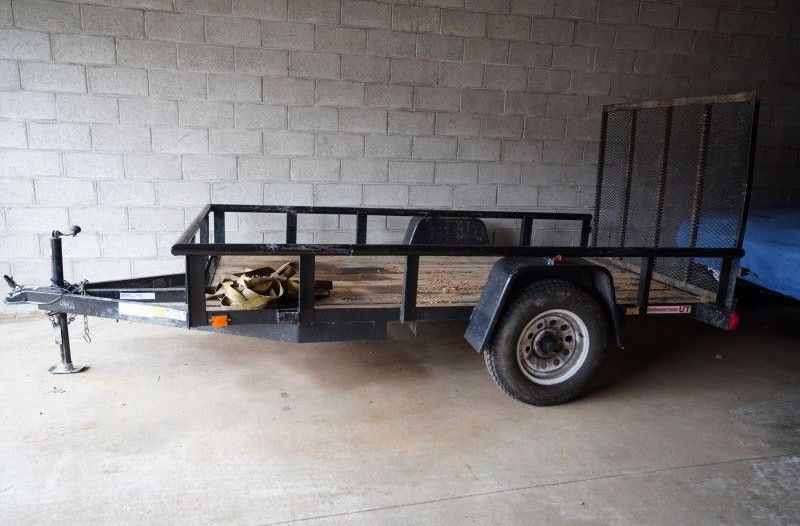 A trailer is parked in a garage next to a brick wall.