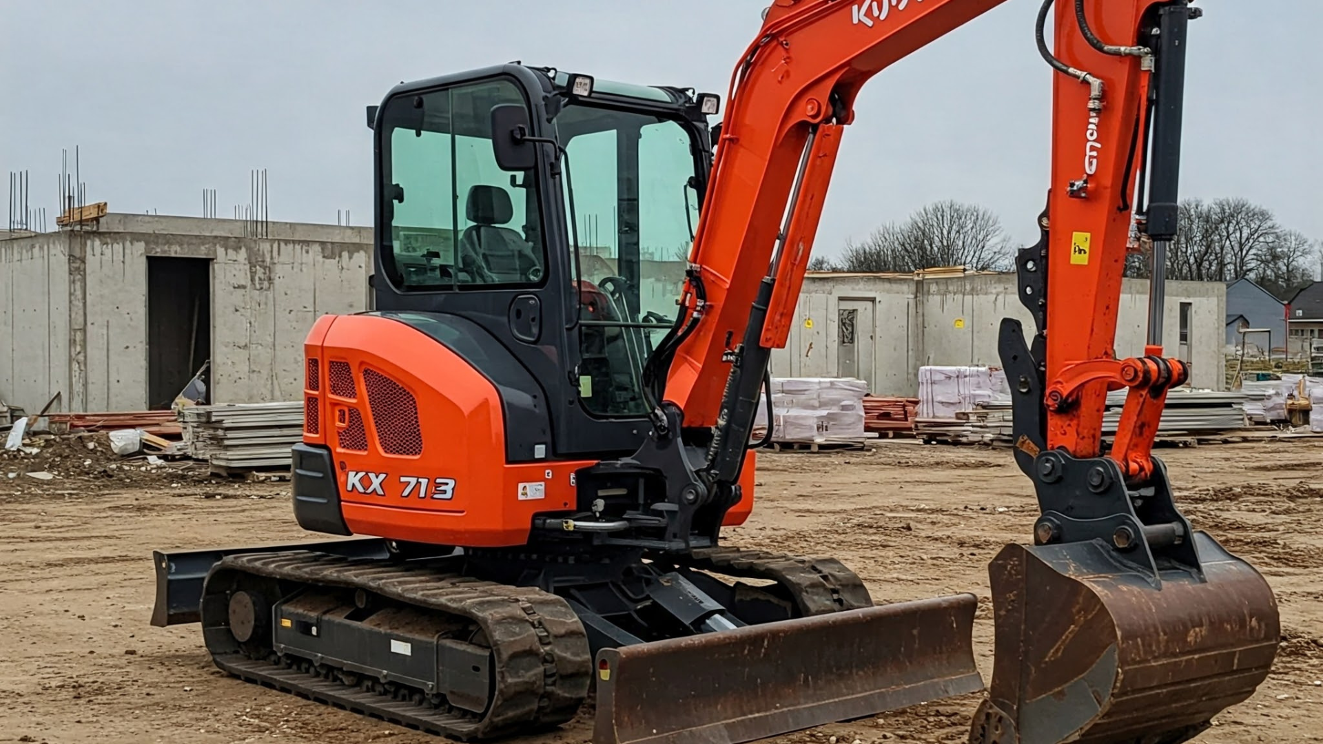 An orange and black excavator is parked in a dirt field.