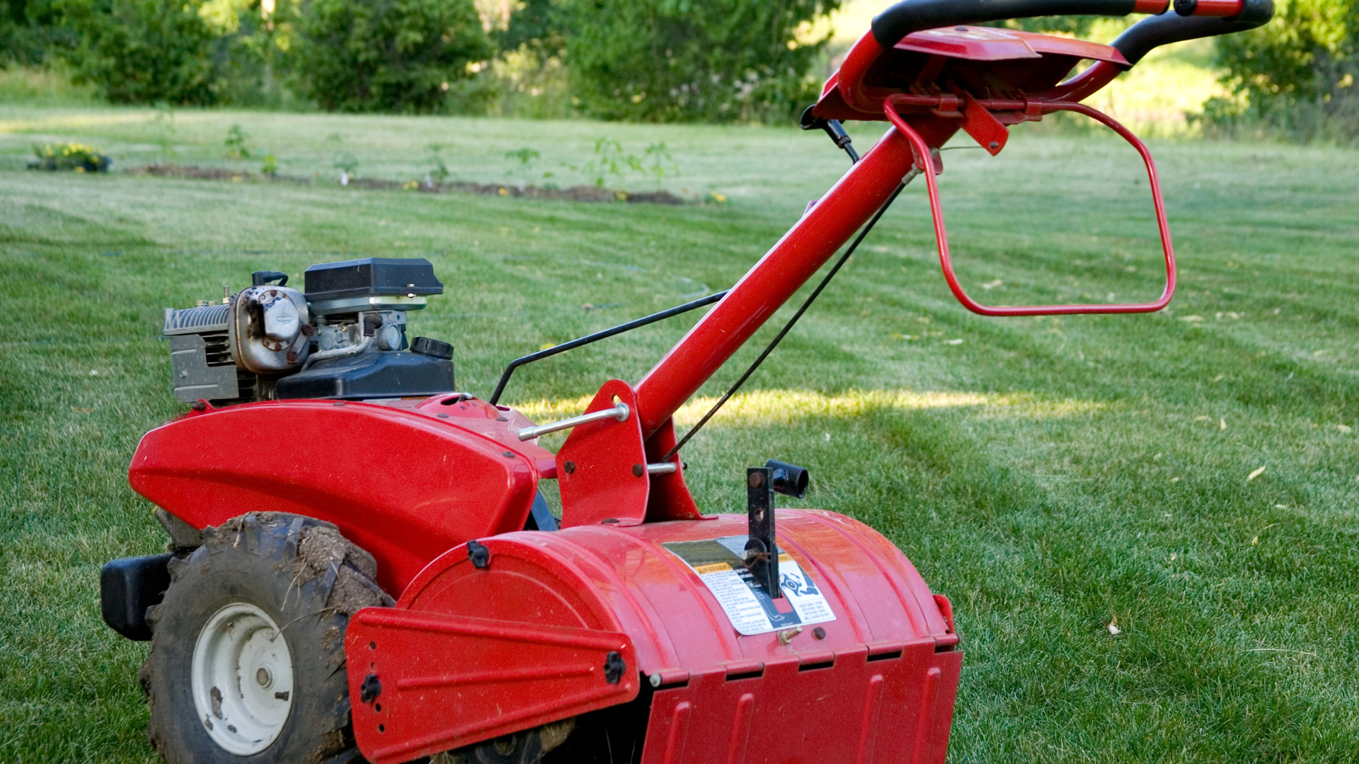A yellow tractor is parked in front of a white house