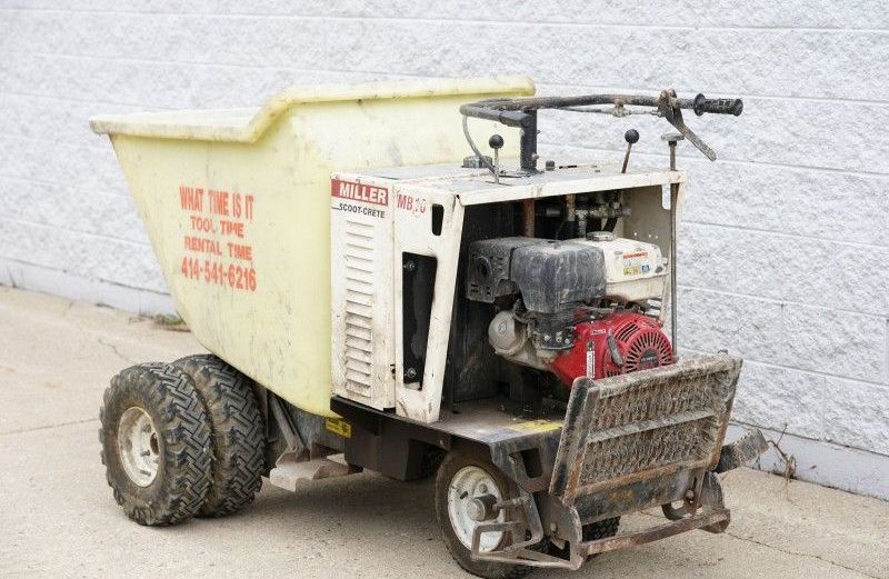 A dump truck is parked on the side of the road next to a brick wall.