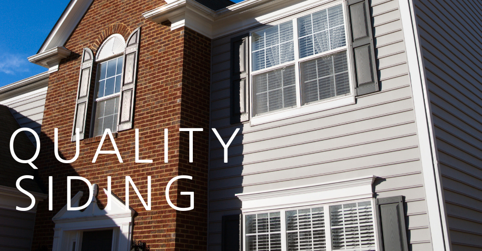 A two-story suburban home with red brick and grey horizontal siding, with the text