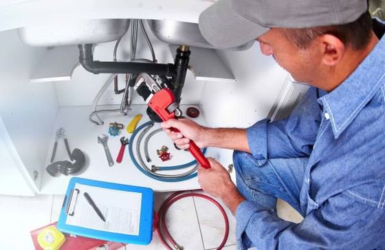 AA Plumbing repairman works on a customer's sink pipes