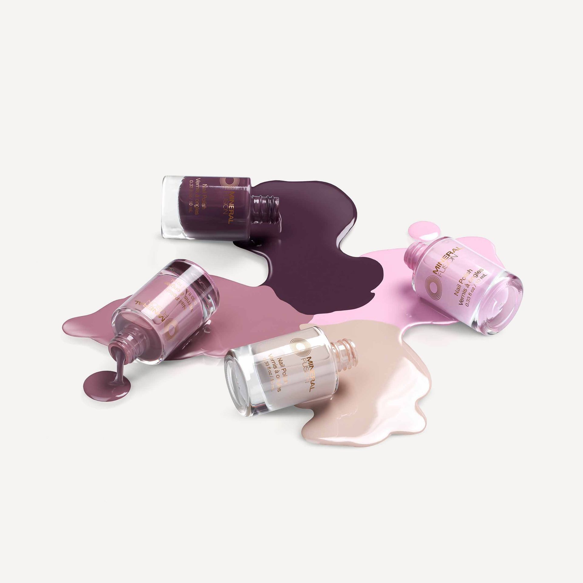 4 Mineral Fusion nail polishes spilling from glass bottles