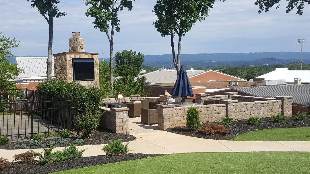 A patio area with a fireplace and umbrellas in a residential area.