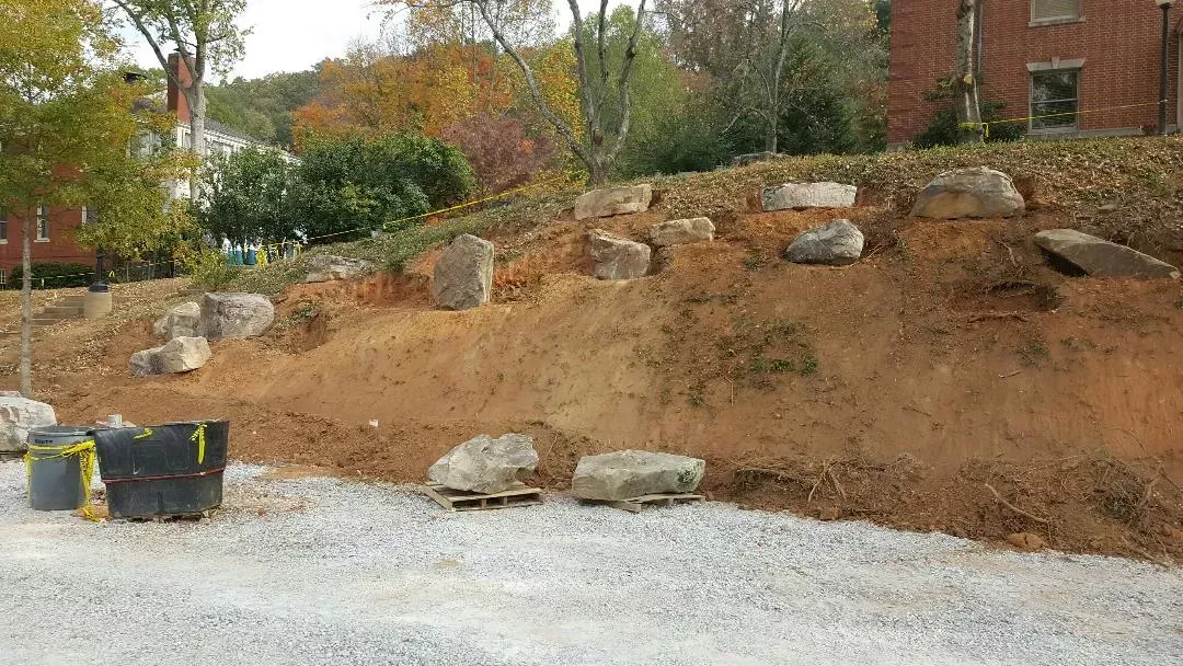 A large pile of dirt and rocks is sitting on top of a gravel hill.