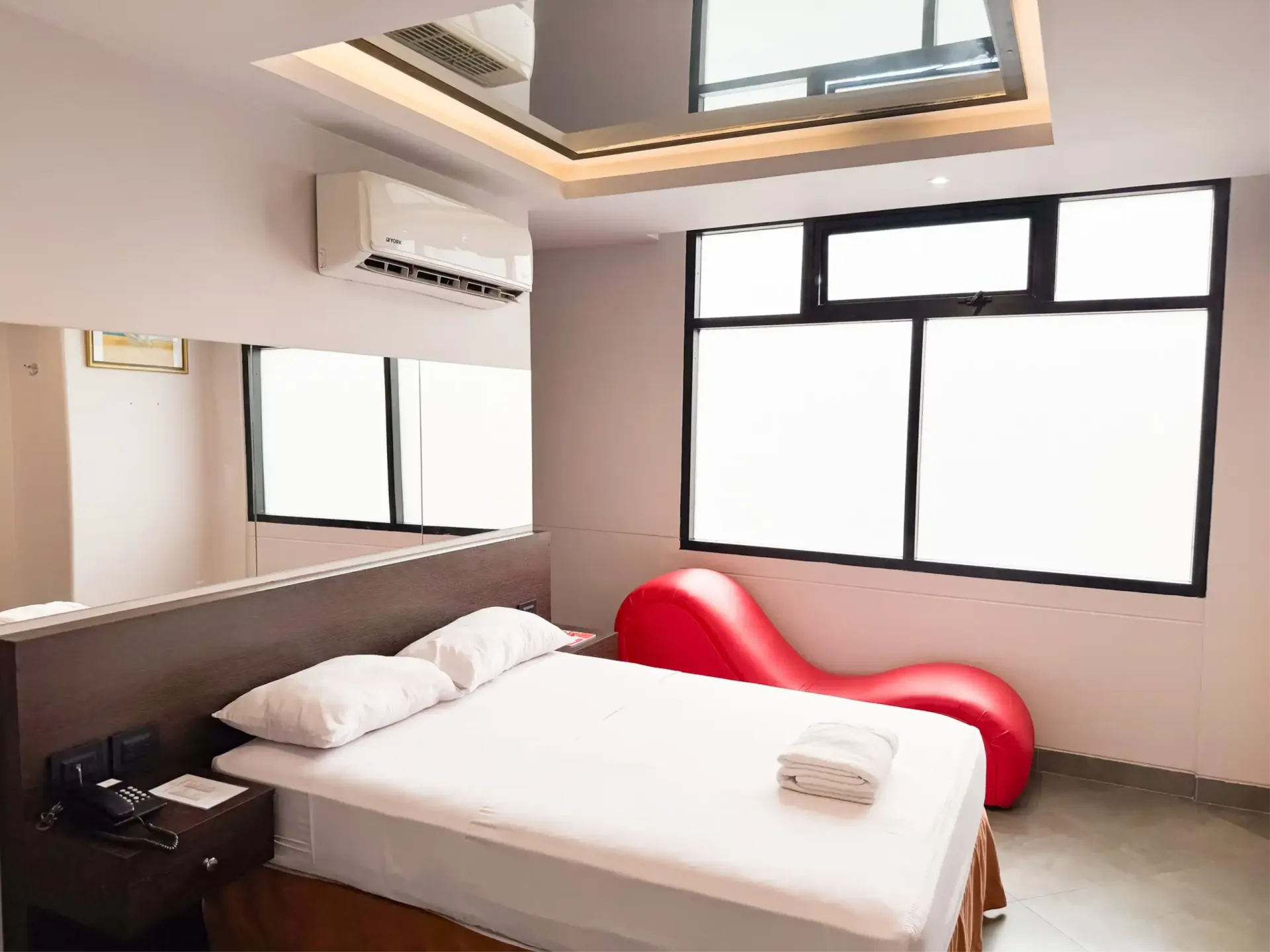 Habitación decorada con cuadros, tv, aire acondicionado y jacuzzi