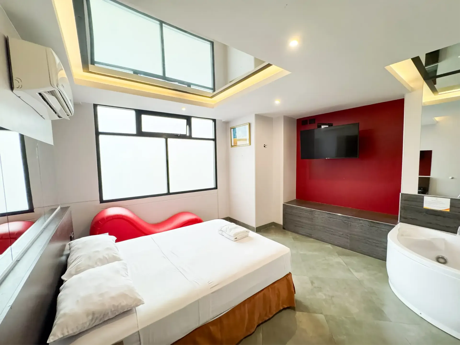 Habitación decorada con cuadros, tv, aire acondicionado y jacuzzi