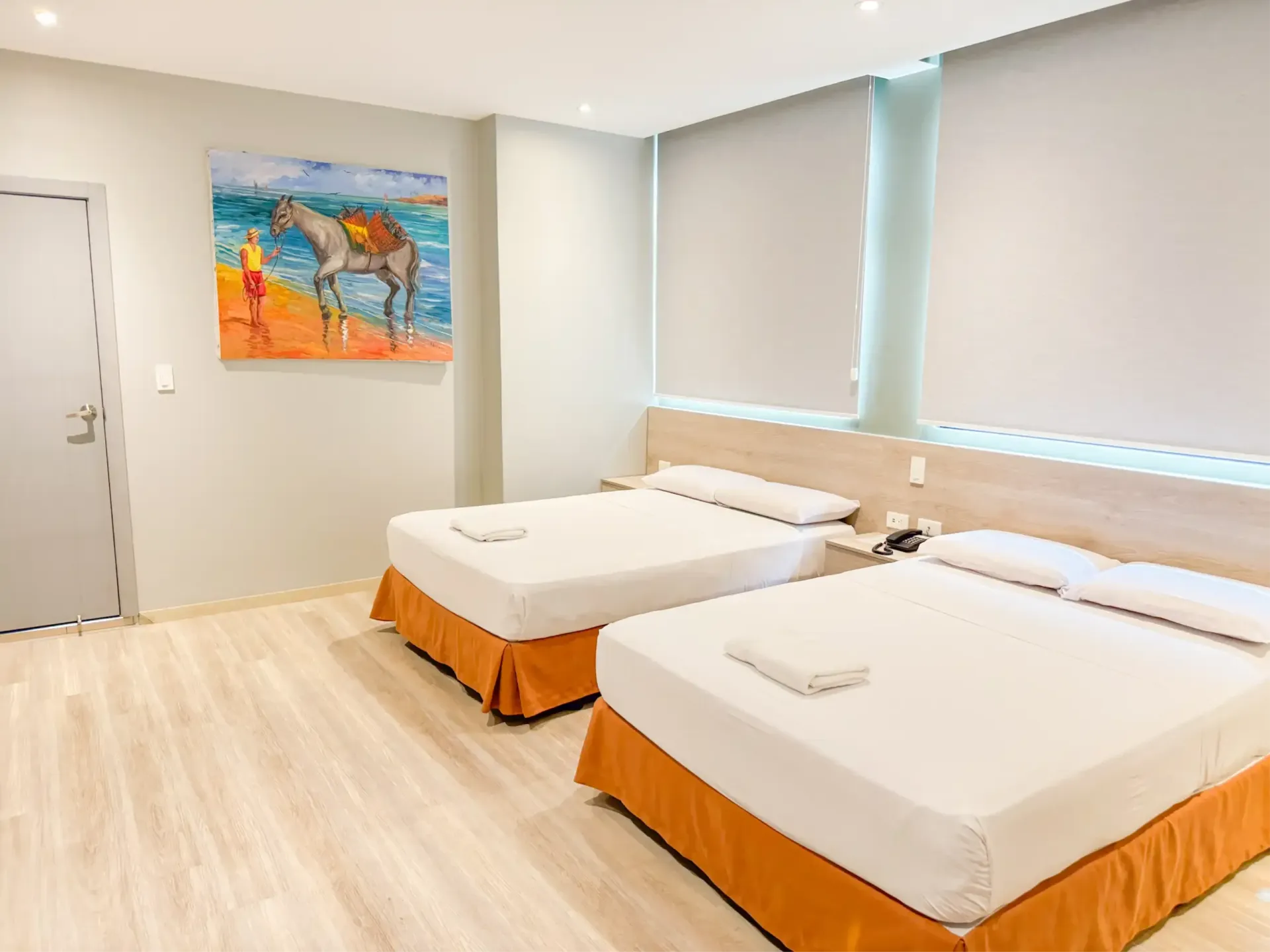 Un dormitorio con dos camas y una pintura en la pared