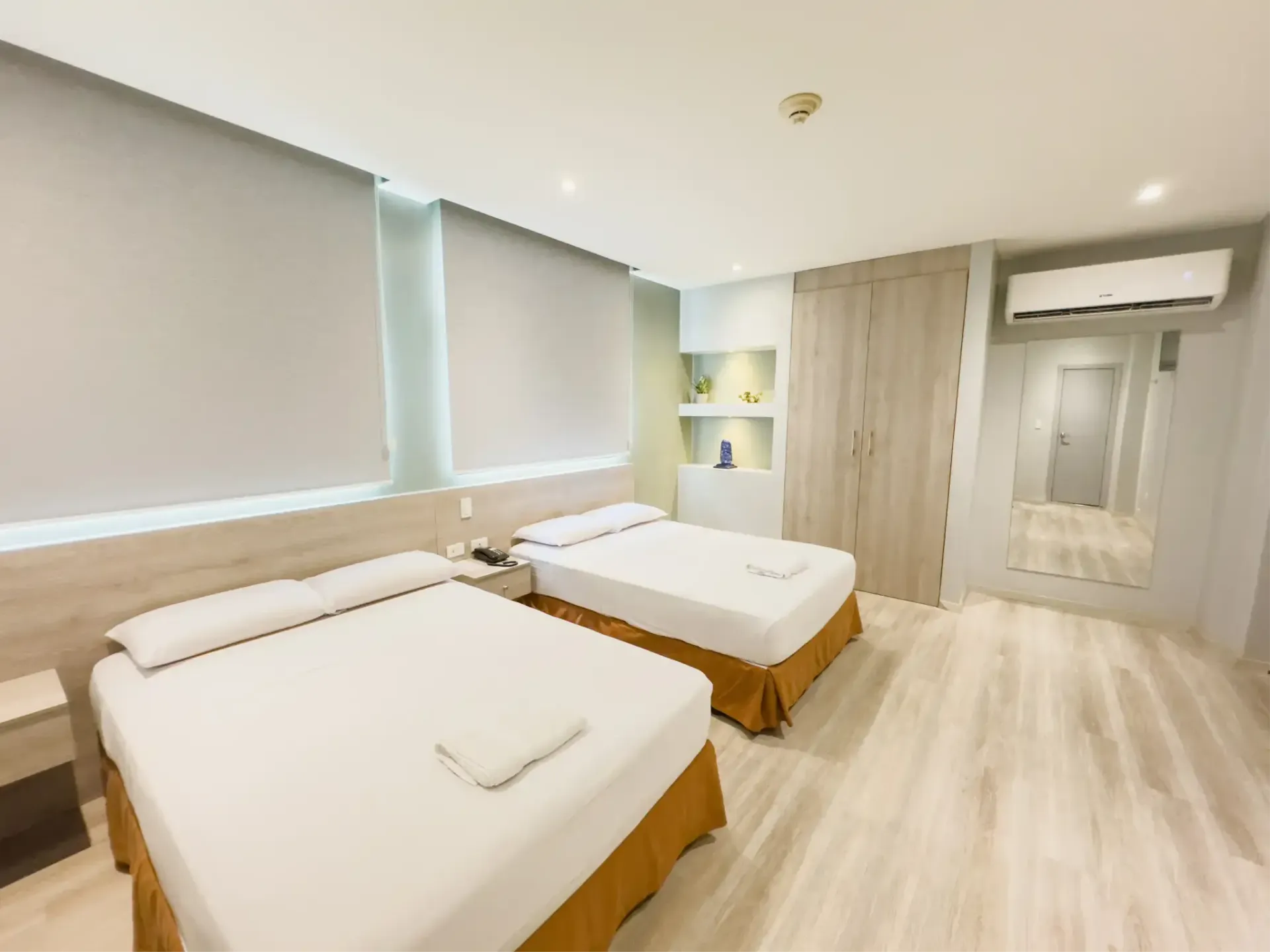 Una habitación de hotel con dos camas y una imagen de elefantes en la pared