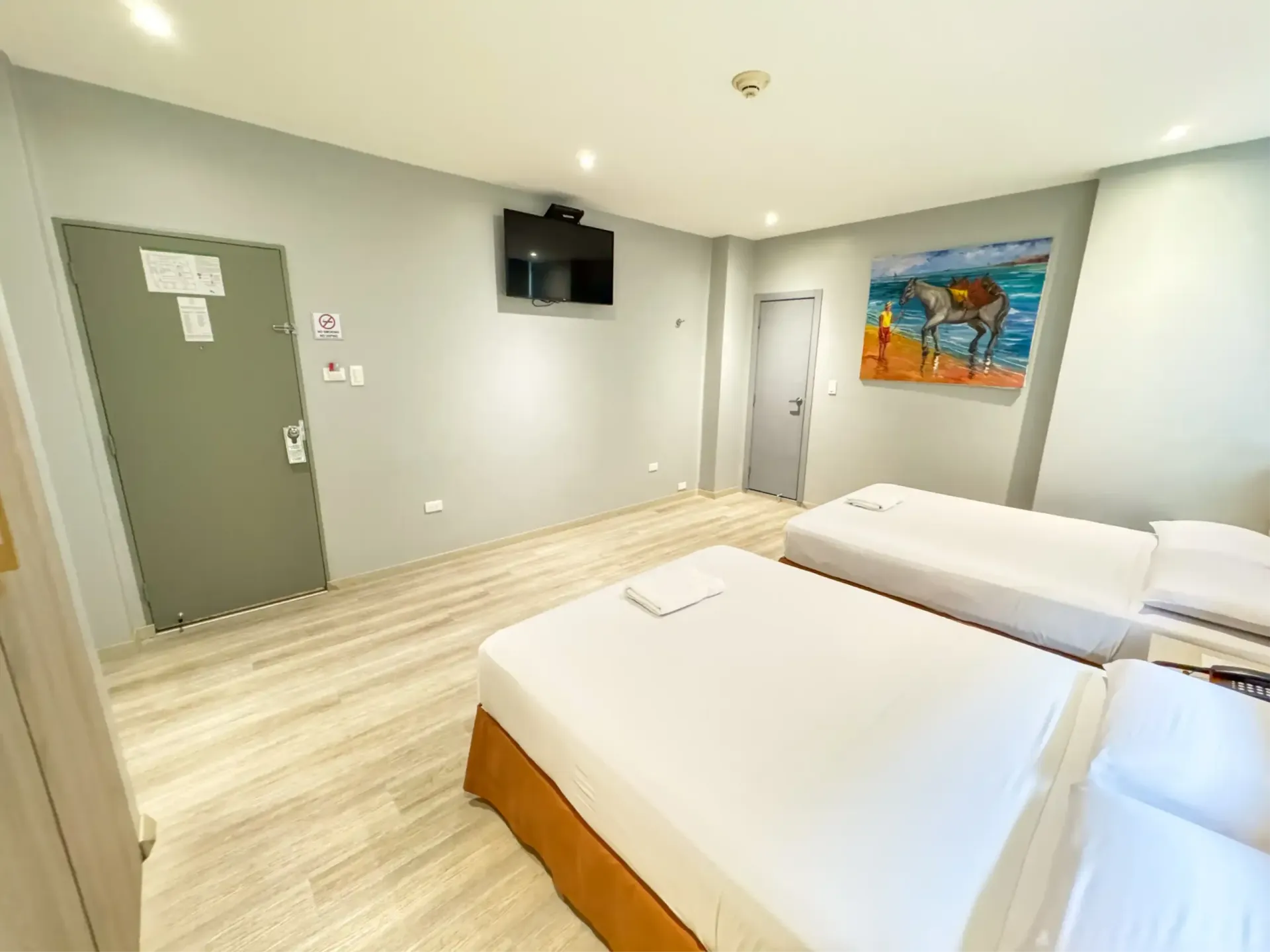 Un dormitorio con dos camas, una pintura en la pared y una ventana con las cortinas cerradas