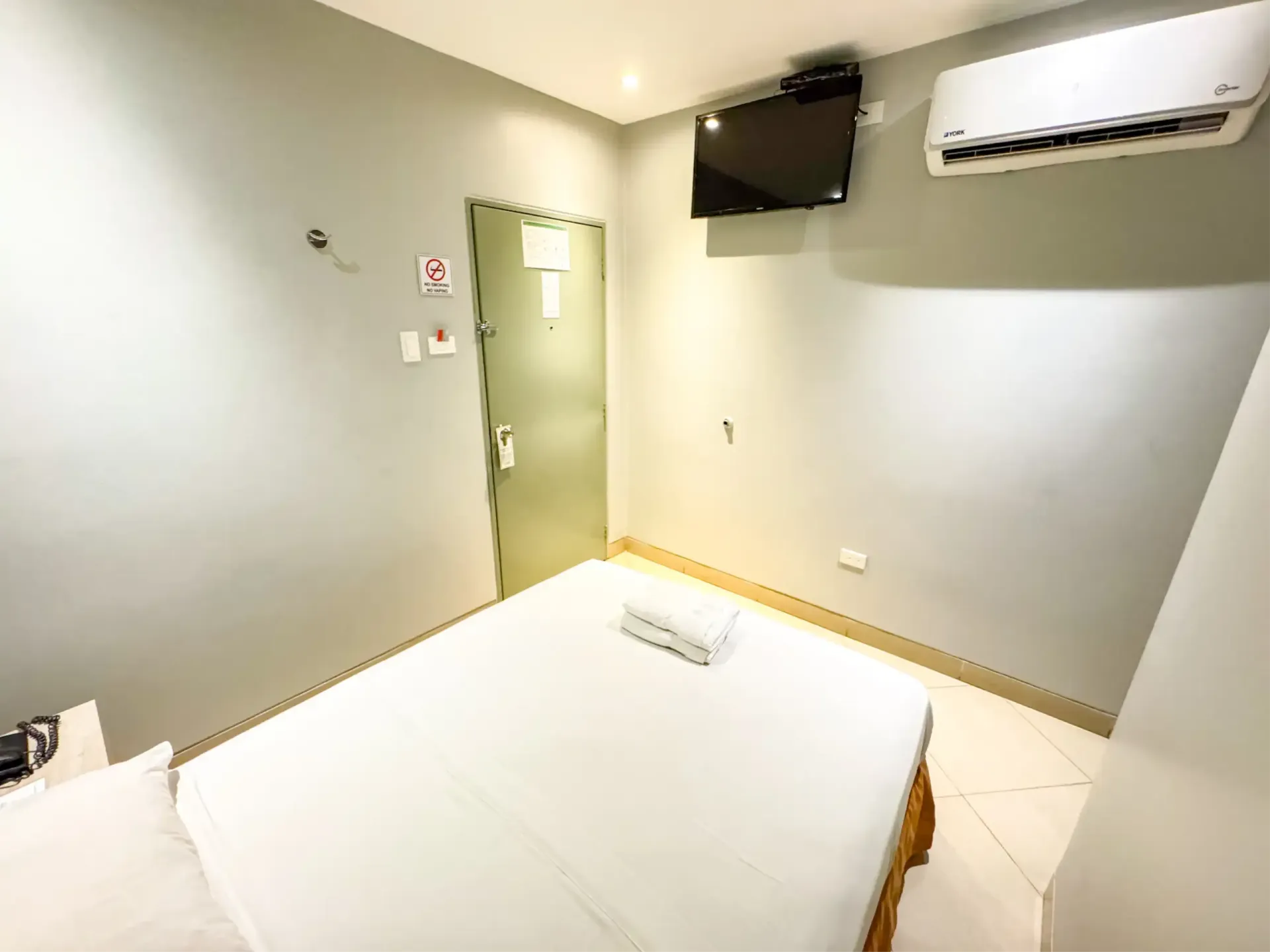 Habitación con una pintura que cuelga sobre la pared encima de la cama