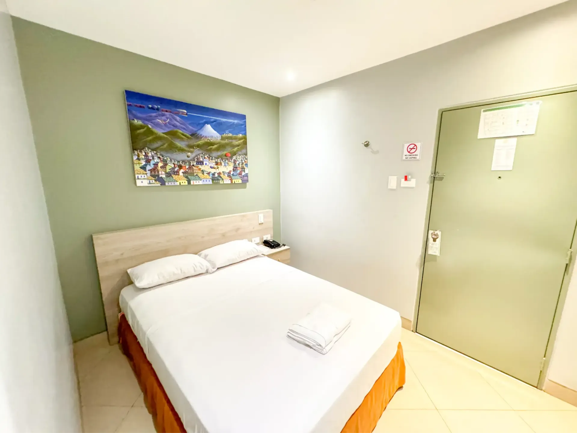Habitación de hotel con una cama y una pintura en la pared