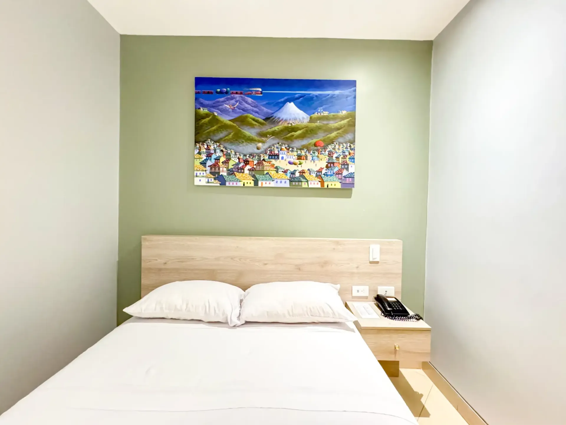 Un dormitorio con una cama y una pintura en la pared