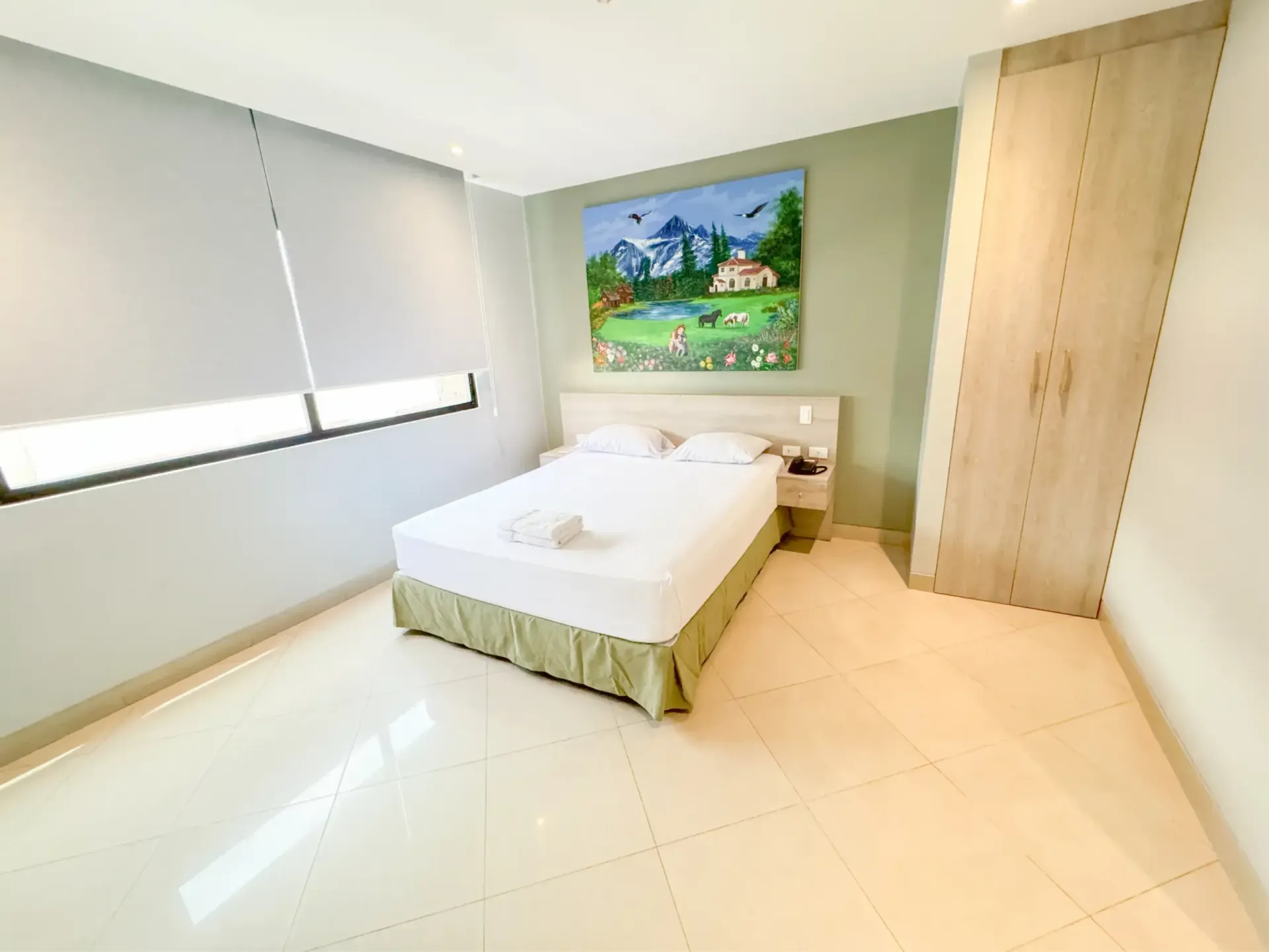 Un dormitorio con una gran pintura sobre la pared encima de la cama