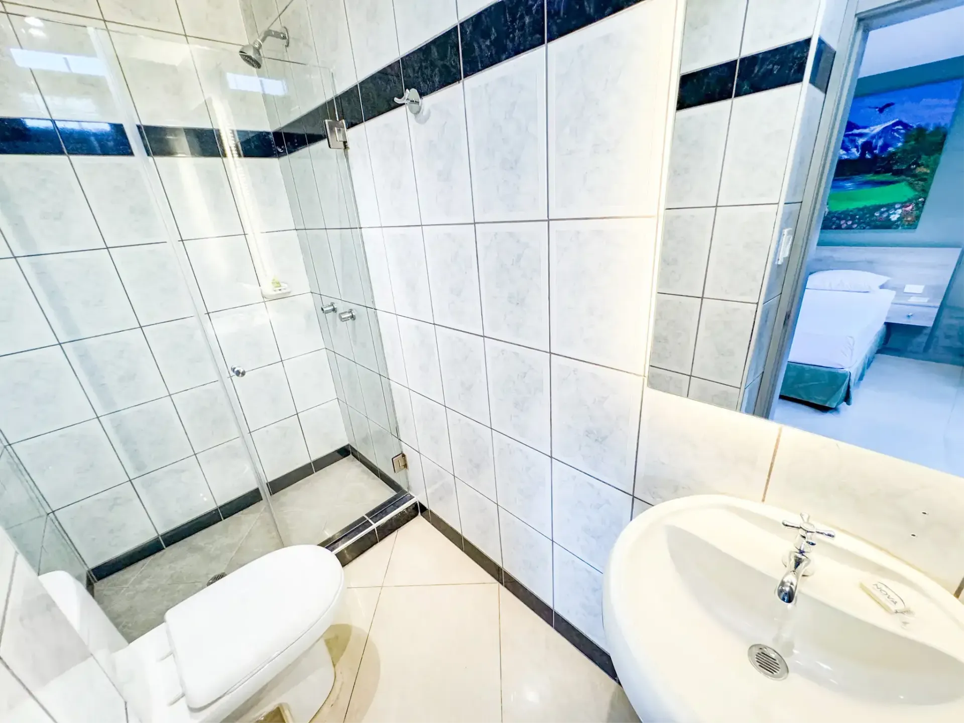 Encima de la cama grande hay una pintura en la pared