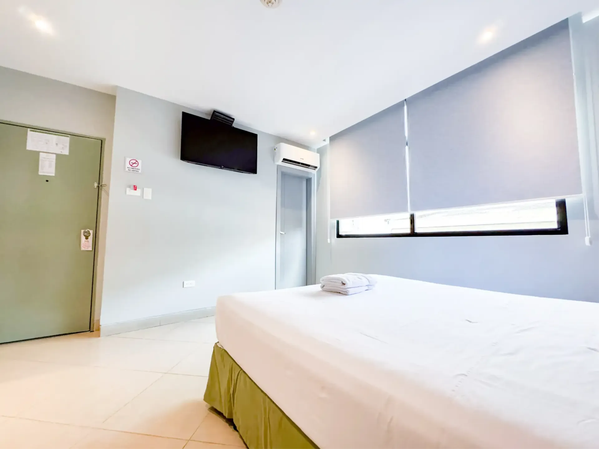 En la pared, sobre la cama, hay una pintura de un árbol