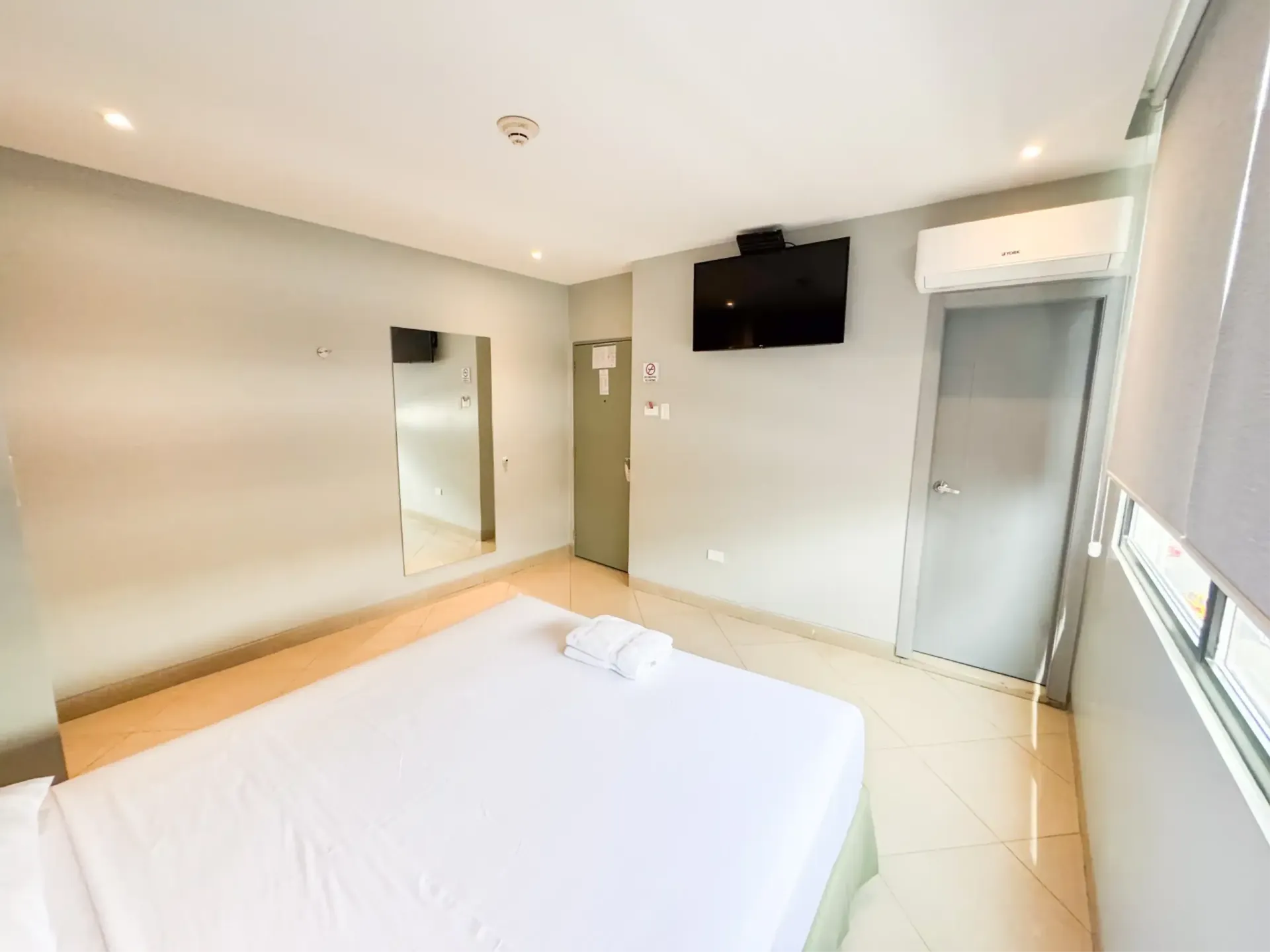 Una habitación de hotel con una cama grande y una pintura en la pared