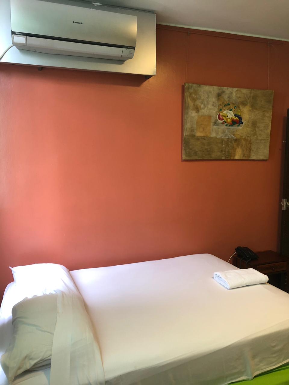 Dormitorio con una cama y una pintura en la pared