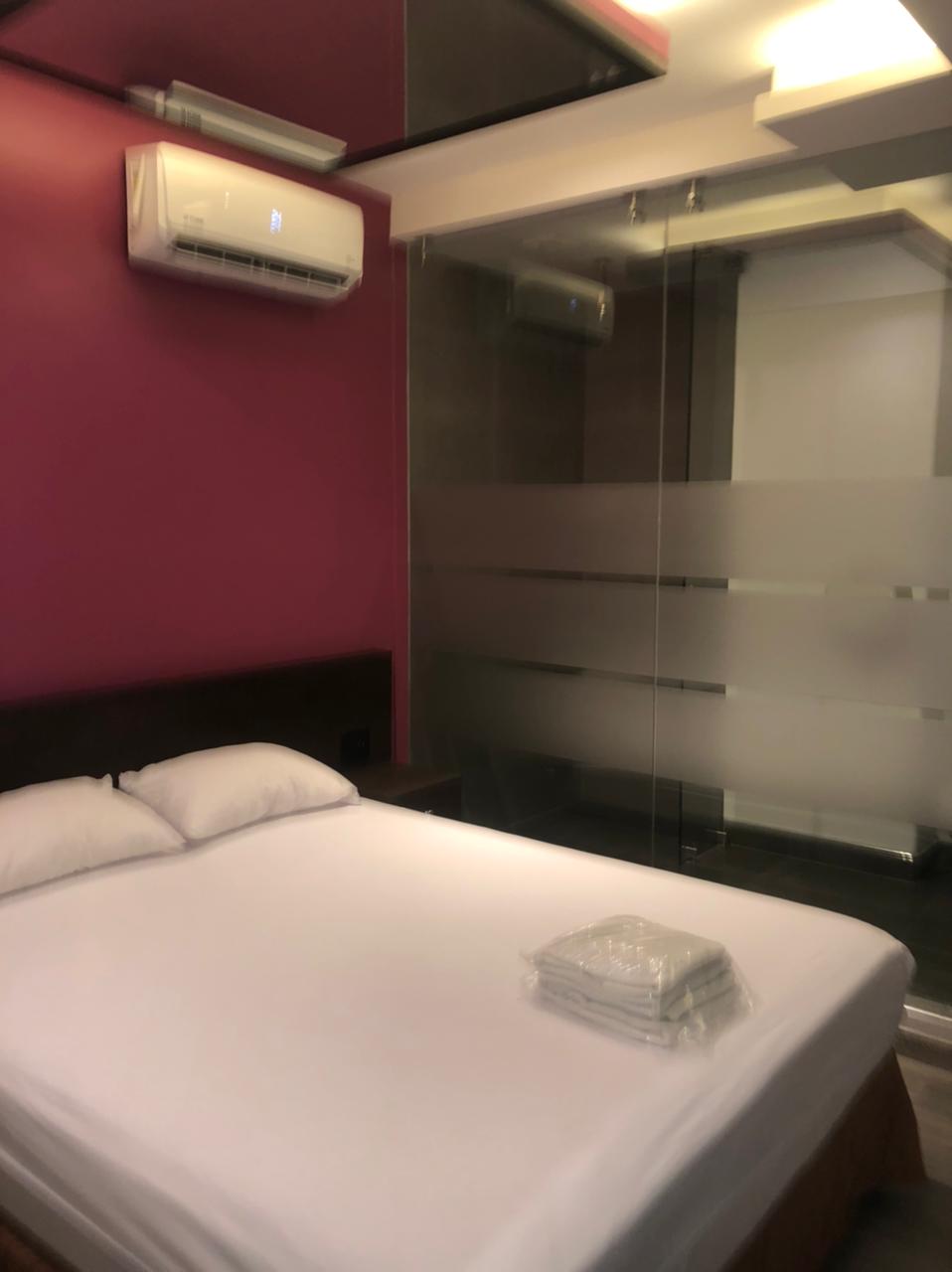 Una cama en una habitación de hotel con una pared morada